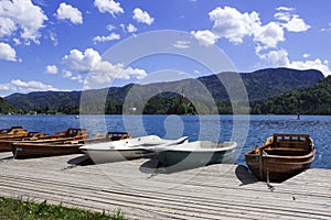 Wooden boats on the pier on the background of the castle on Lake Bled. Beautiful view, nature, calm