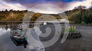 Wooden boats in a row on a lake. Ireland.