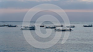 Wooden boats during sunset at Crystal Bay Beach in Nusa Penida, Indonesia