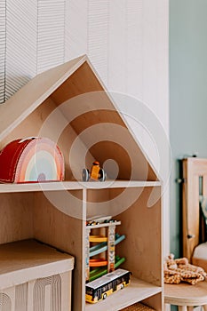 Wooden book shelf with brightly colored toys and books neatly arranged on them