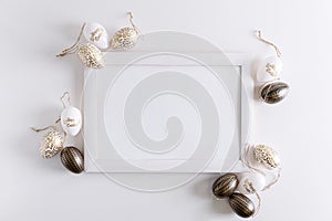Wooden border decorated of white tulips and Easter eggs on white background. Easter celebration concept. Copy space. Top view