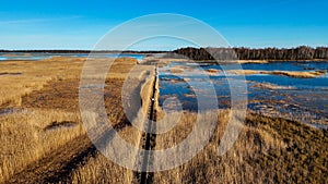 Wooden Bords Trail Through the Kaniera Lake Reeds Aerial Spring Shot Lapmezciems, Latvia