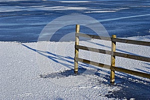 A Wooden boundary Picket Fence at the periphery of Murton Loch with the winter sun casting long shadows