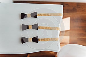 Wooden bow ties on a ivory table