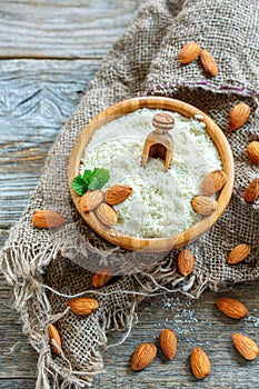 Wooden bowl with almond, mint and almond flour.