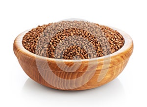 Wooden bowl with buckwheat isolated on white background.