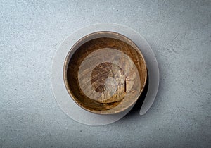 Wooden bowl on a concrete stone surface. Texture and texture of wood and concrete