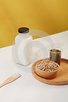 Wooden bowl containing soybeans and a beaker of green beans placed on a tray