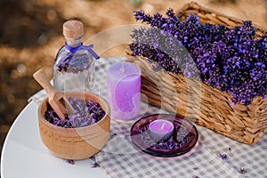 Wooden bowl with dried lavender on field background. Flower herbal tea drink. Aromatherapy, medicine ingredient. Calming beverage