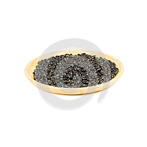 Wooden bowl of dry black beans isolated on white