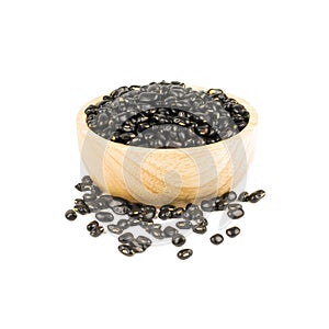 Wooden bowl of dry black beans isolated on white