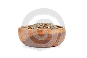 Wooden bowl filled with dried cumin or zara seeds on a white background