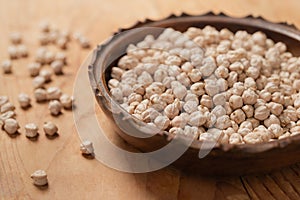 Bowl of cicerale raw chickpeas on wooden table photo