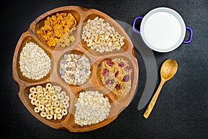 Wooden bowl with mixed breakfast cereals and blue bowl with fresh milk