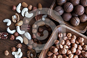 Wooden bowl with mixed nuts on table top view. Healthy food and snack. Walnut, pistachios, almonds, hazelnuts and