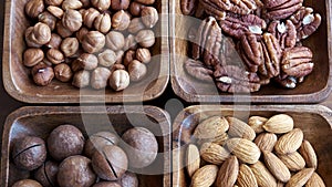 Wooden bowl with mixed nuts on table top view. Healthy food and snack. Walnut, pistachios, almonds, hazelnuts and