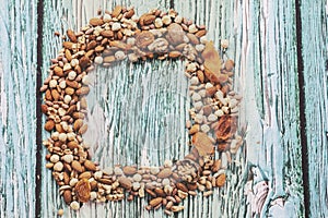 Wooden bowl with mixed nuts on white table top view. Healthy food and snack. Walnut, pistachios, almonds, hazelnuts