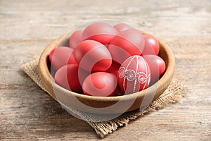Wooden bowl with red painted Easter eggs