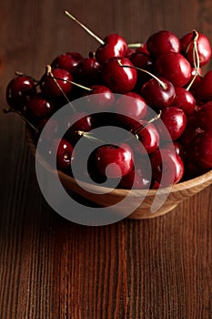 Wooden bowl with red ripe cherries