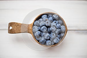 Wooden bowl with sweet summer blueberries
