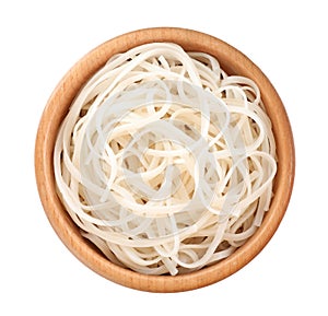 Wooden bowl of tasty cooked rice noodles isolated on white, top view
