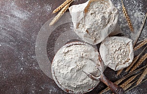 Wooden bowl of wheat flour on kitchen background top view. Ingredient for baking photo