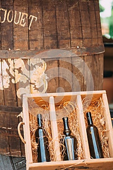 A wooden box with a bottle of wine and barrel