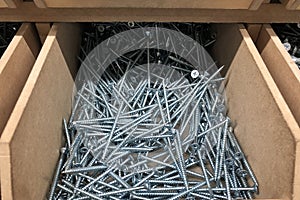 Wooden box filled with long screws. Reparing equipment