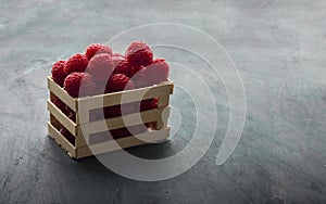 Wooden box with fresh red blackberries, which are a source of vitamins and minerals photo