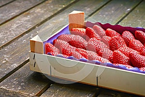 Wooden box with fresh red strawberries on an old wooden table