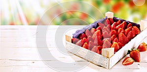 Wooden box of fresh ripe red strawberries