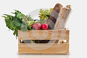 Wooden box with fresh vegetables and organic greens on white background. Bio organic food. Detox diet. Selective focus. Space for