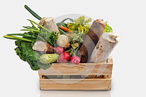 Wooden box with fresh vegetables and organic greens on white background. Bio organic food. Detox diet. Selective focus. Space for