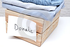 Wooden box full of old used clothes for donation and charity, recyclind and reusing clothes