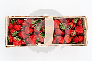 Wooden box full of red ripe strawberries isolated on white background, photographed directly from above. Harvesting summer fruits