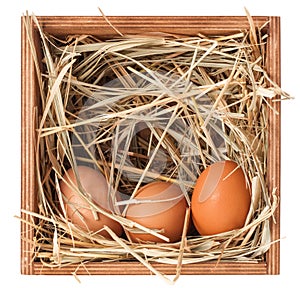 Wooden box with hay and eggs