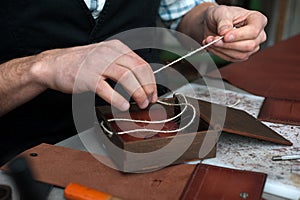 a wooden box for packing finished handmade leather products. The craftsman prepares a handmade box. Small business