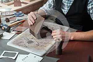 A wooden box for packing finished handmade leather products. The craftsman prepares a handmade box. Small business