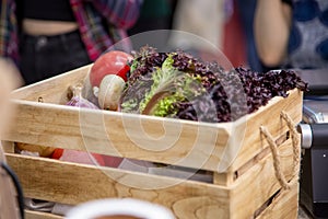 Wooden box with set of fresh organic vegetables garlic, champignons, onion, tomatoes, lettuce leaves. Concept of