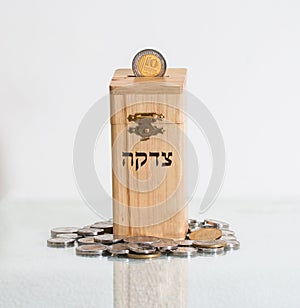 Wooden box Tzedakah, translating the text charity