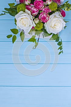 Wooden box with white and pink roses and chrysanthemums on turquoise wooden board. Decoration of home. Flowers boxes. Wedding