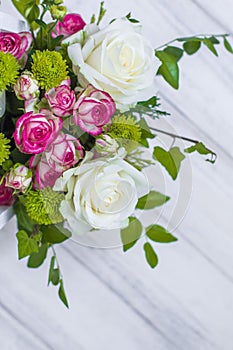 Wooden box with white and pink roses and chrysanthemums on white wooden board. Decoration of home. Flowers boxes. Wedding