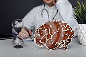 Wooden brain and hourglass in doctor& x27;s office. Dementia concept