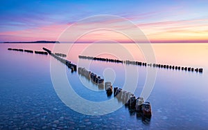 Wooden breakwaters pointing towards the sunset in Dranske, Ruegen, Germany