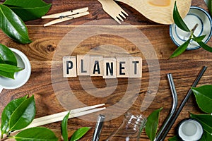 The wooden brick with words ` PLANET ` on wooden background. ECO concept with recycling symbol and leaves