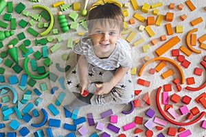 Wooden bricks Montessori material rainbow spectrum. Little cute boy plays with cubes.