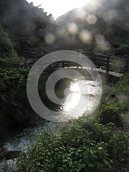 Wooden Bridge above River with Sunshine