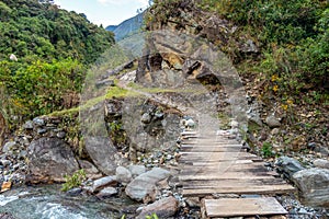 Wooden bridge across mountain river photo