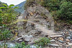 Wooden bridge across mountain river photo