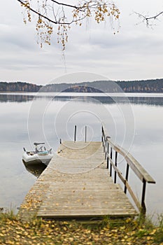 Wooden bridge into cold autumn lake